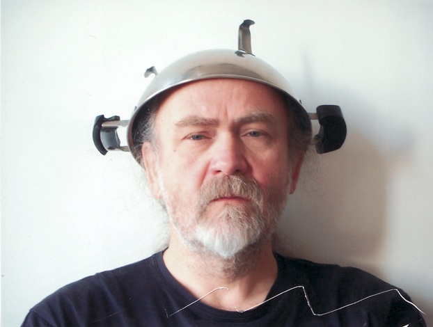 It shows the artist Andreas Wachter wearing a metal helmet in 2016.