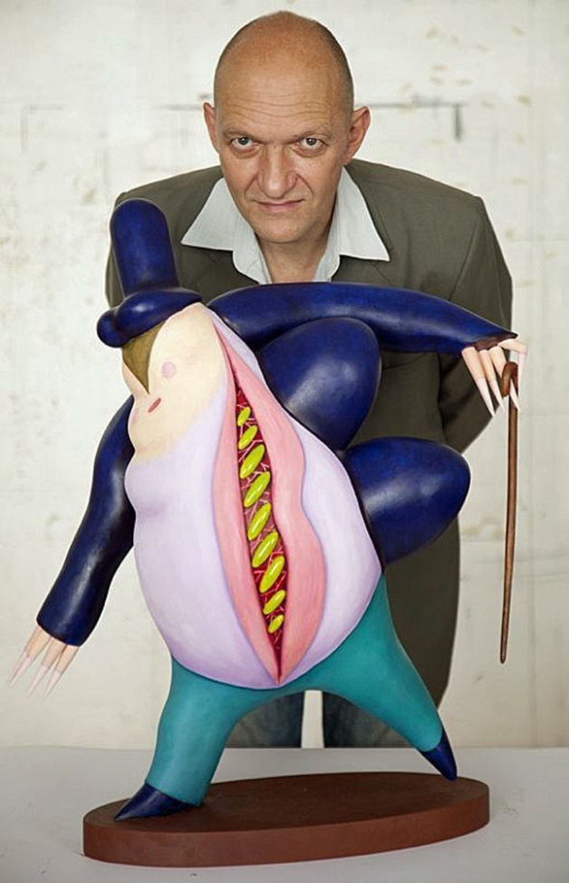 It shows the artist looking straight ahead at one of his sculptures.